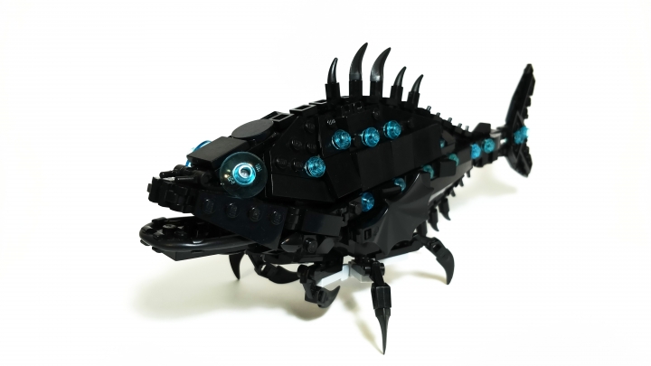 LEGO MOC - Fantastic Beasts And Who Dreams Of Them - Cryptopalus lustrum: Полуночники - некрупные рыбы чаще всего достигающие 20 - 26 см. в длину. Они обладают уплощённым с боков вытянутым телом среднего размера головой, и относительно крупным раздвижным ртом. Спинной плавник небольшой, обычно несёт 4-6 лучей, маленьких жировой плавник сильно сдвинут к двухлопастному гомоцеркальному хвостовому плавнику. Между спинным и жировым плавником тянется гребень из 5-7 мелких шипов. Анальный плавник состоит обычно из трёх крупных и множества мелких шипов. Под грудными плавниками расположены три пары подвижных лапок - видоизменённых лучей брюшных плавников (остальные лучи брюшных плавников редуцированы). Тело покрыто  циклоидой чешуёй. Бока и хвостовой стебель рыбы так же усеяны фотофорами (видоизменёнными светящимися чешуйками). Полуночники обычно имеют пепельно-чёрную окраску, в то время как фотофоры испускают блёклый голубоватый свет.<br />
На родине в Южной Америке полуночники обитают в бедных кислородом временных водоёмах и насильно заросших илистых участках рек и озёр. Всеядны: питаются различными мелкими животными, реже поедают водоросли и плоды, упавшие в воду. В свою очередь полуночники зачастую становятся жертвами крупных хищных рыб и других пресноводных хищников. Размножаются круглый год, при наличии пригодных для этого водоёмов. Способны дышать жабрами и атмосферным воздухом (буквально заглатывая его, после чего газообмен происходит в плавательном пузыре, сообщающимся с пищеводом). Способны переползать из одного водоёма в другой при помощи трёх пар лапок.<br />
<br />
